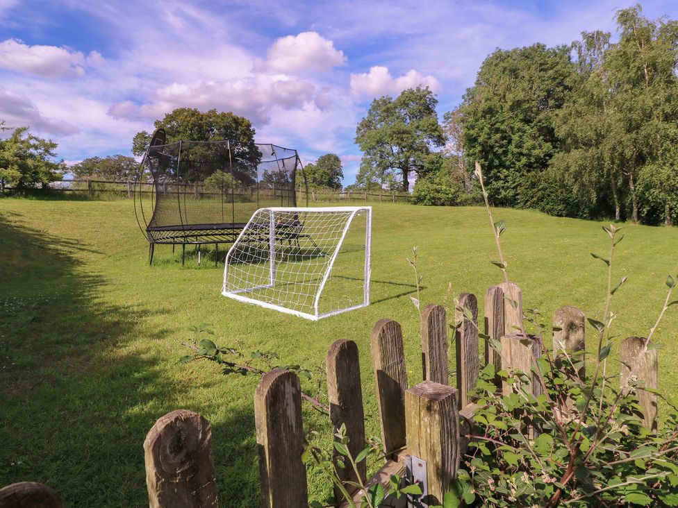 A garden with a goal post and trampoline at The Old Hall Westonbit Nr Tetbury