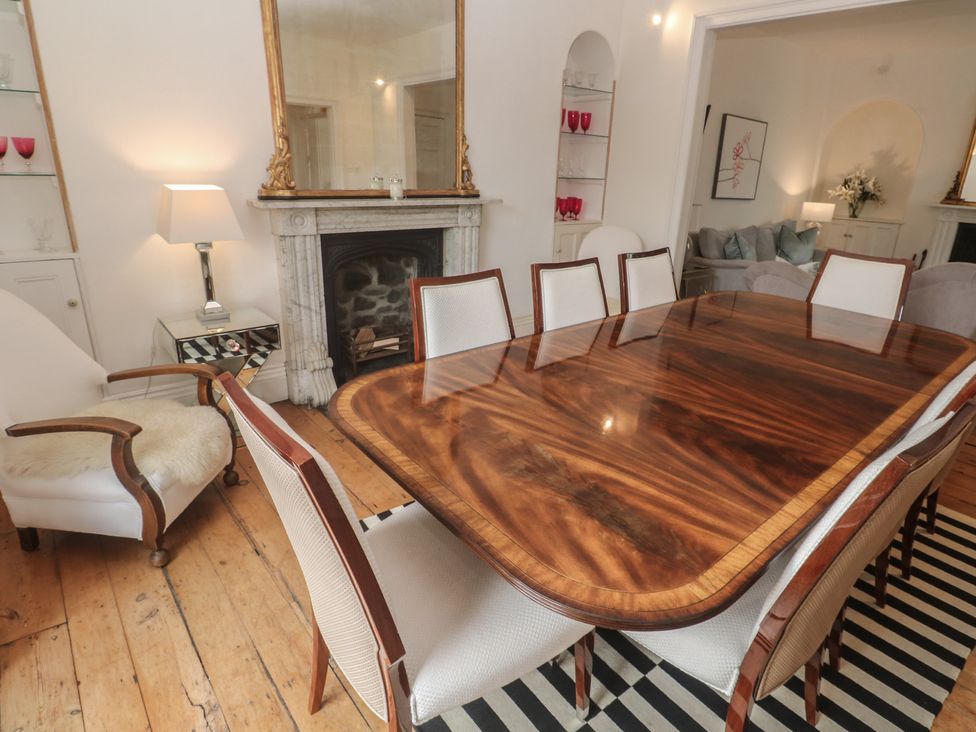 A dining room with a wooden table and chairs at Scillonia in Penzance
