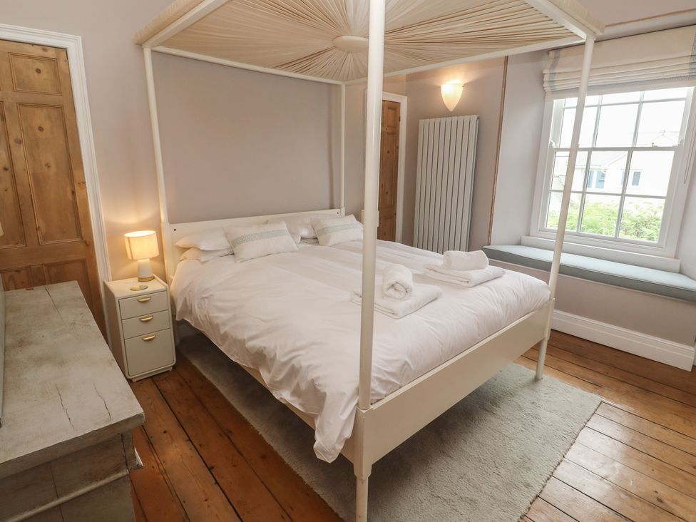 A bedroom with a four-poster bed and a window seat at Scillonia in Penzance