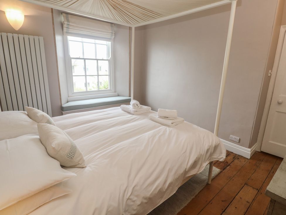 A bedroom with a bed and a window at Scillonia in Penzance