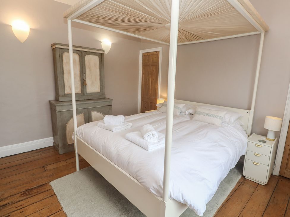 A bedroom with a four-poster bed and wardrobe at Scillonia Penzance