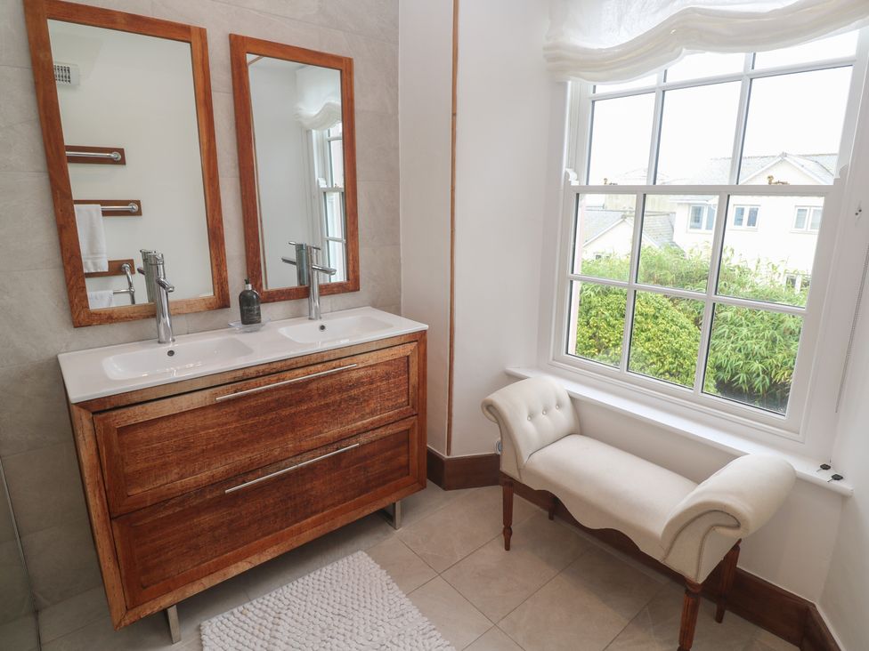 A bathroom with a double sink vanity and mirrors at Scillonia in Penzance