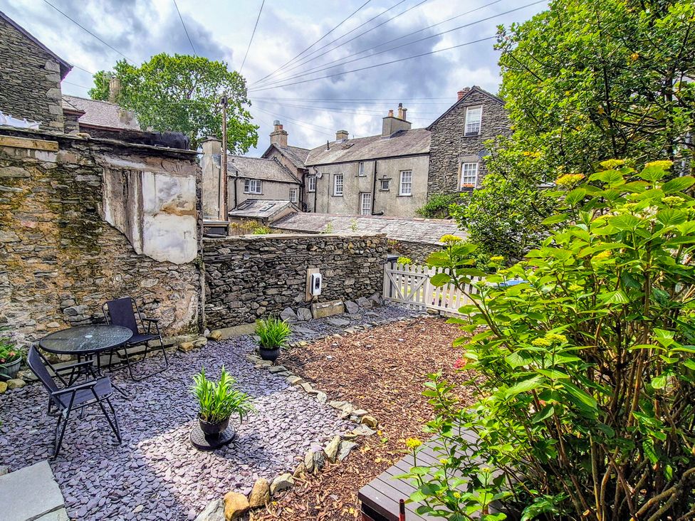 A garden with a table and chairs and plants at The Wonky Burrow in Bowness-On-Windermere