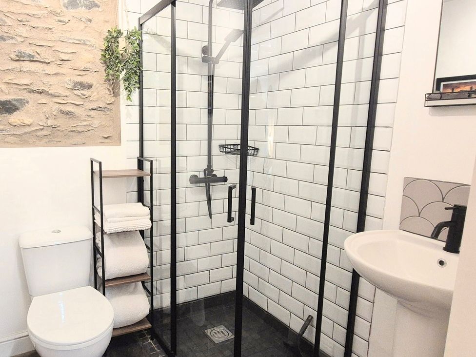A bathroom with a shower, toilet and wash basin at The Wonky Burrow in Bowness-On-Windermere