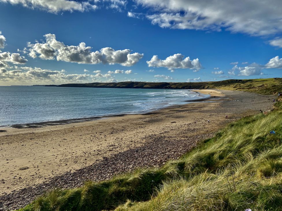 A beach scene with waves and grass at Tower Cottage Near Pembroke