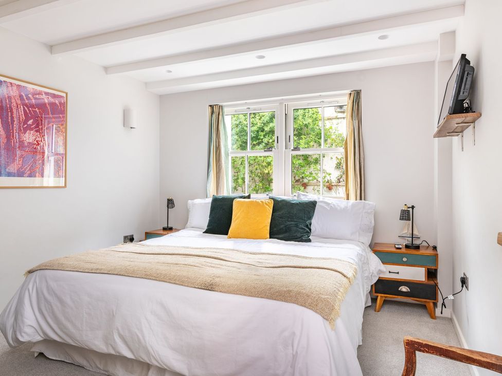 A bedroom with a bed and window at 14 Marine Parade in Lyme Regis