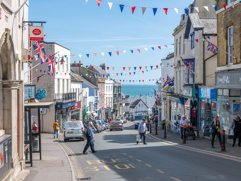 A street view with shops and ocean in the background at 14 Marine Parade in Lyme Regis