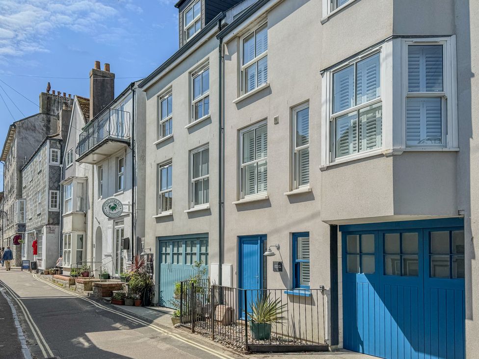 A row of buildings with blue doors at Port House in Lyme Regis