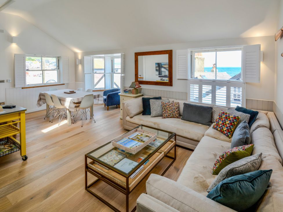 A living room with a sofa and dining area at Port House in Lyme Regis