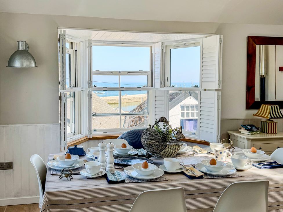 A dining room with a table set for breakfast at Port House in Lyme Regis