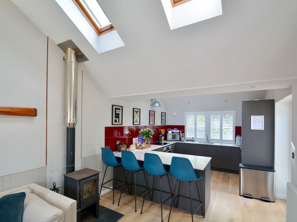 A kitchen with bar stools and a skylight at Port House in Lyme Regis