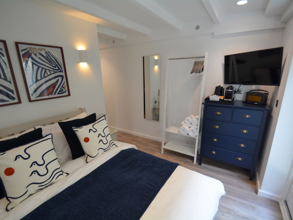 A bedroom with a bed and dresser at Port House in Lyme Regis