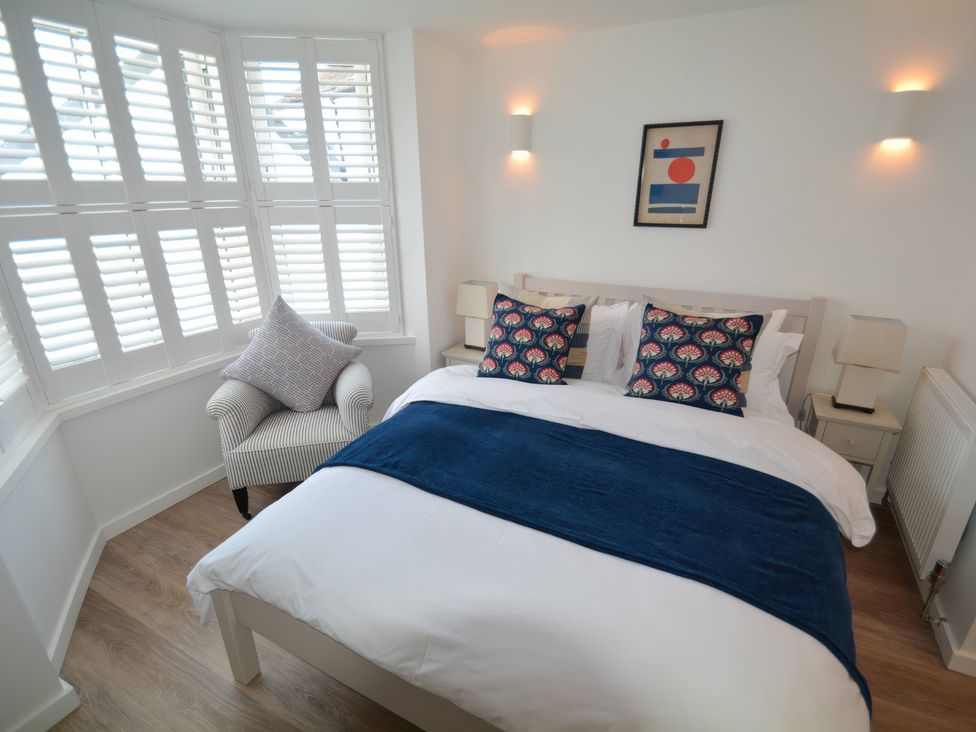 A bedroom with a bed and chair at Port House Lyme Regis