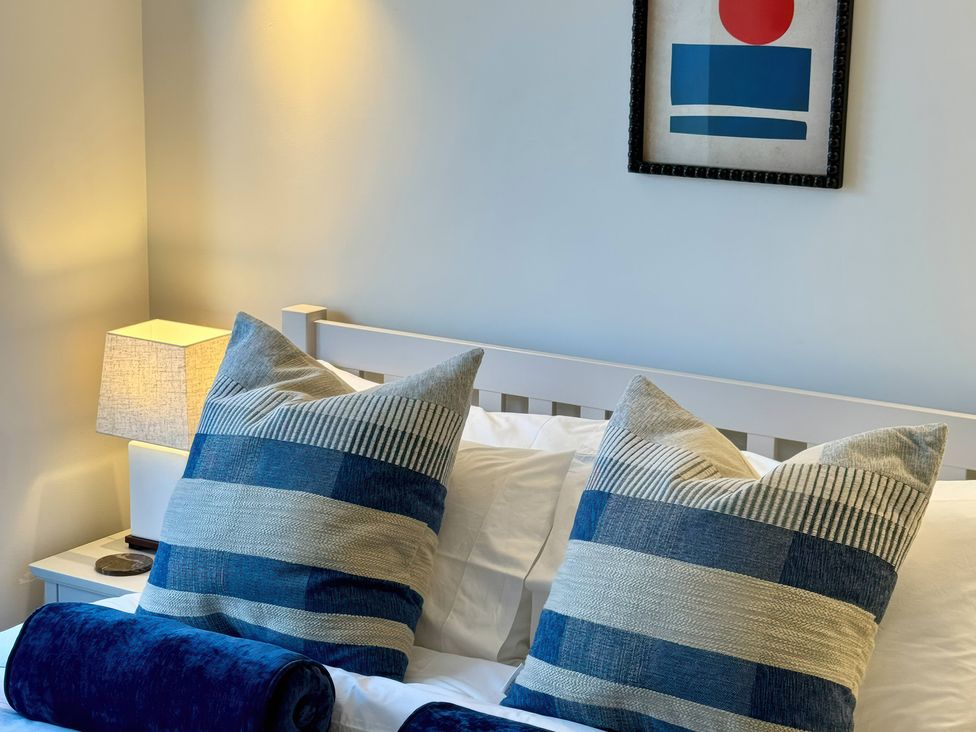 A bedroom with decorative pillows and a lamp at Port House in Lyme Regis