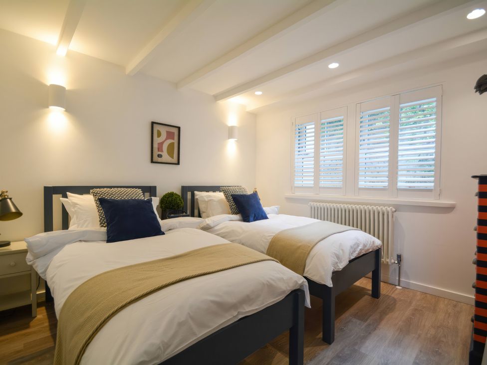 A bedroom with two beds and a window at Port House in Lyme Regis
