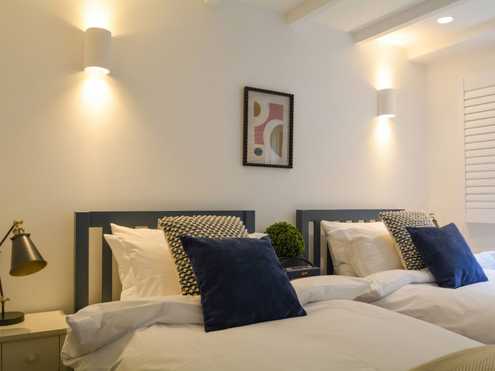 A bedroom with two beds and wall art at Port House in Lyme Regis