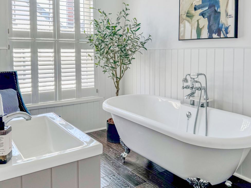 A bathroom with a bathtub and sink at Port House in Lyme Regis