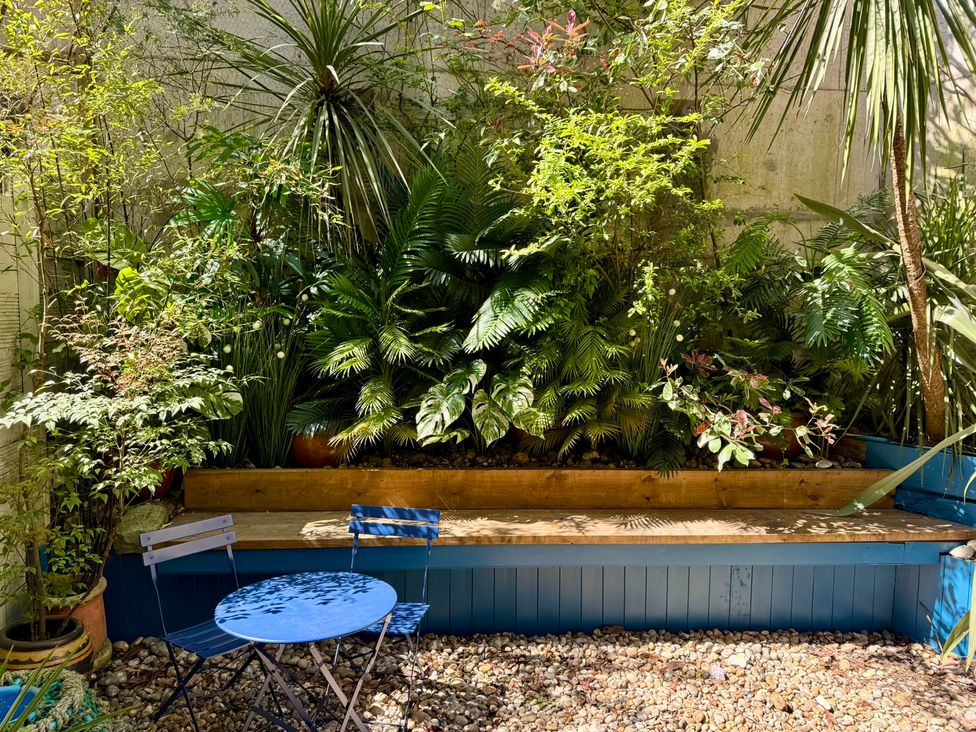 A garden with plants and seating area at Port House Lyme Regis