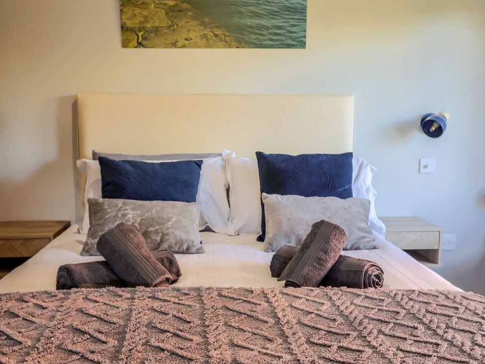 A bedroom with a bed and pillows at Sir George Baker Cabin in Uplyme