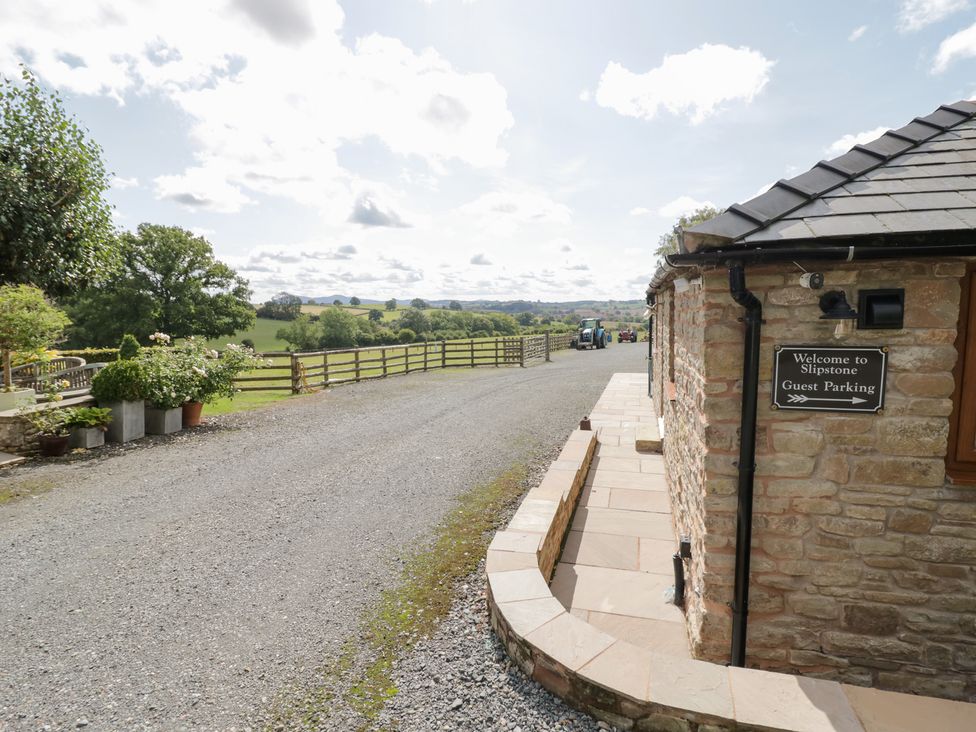 An outdoor parking area with a sign for guest parking at Keepers Barn Bromyard