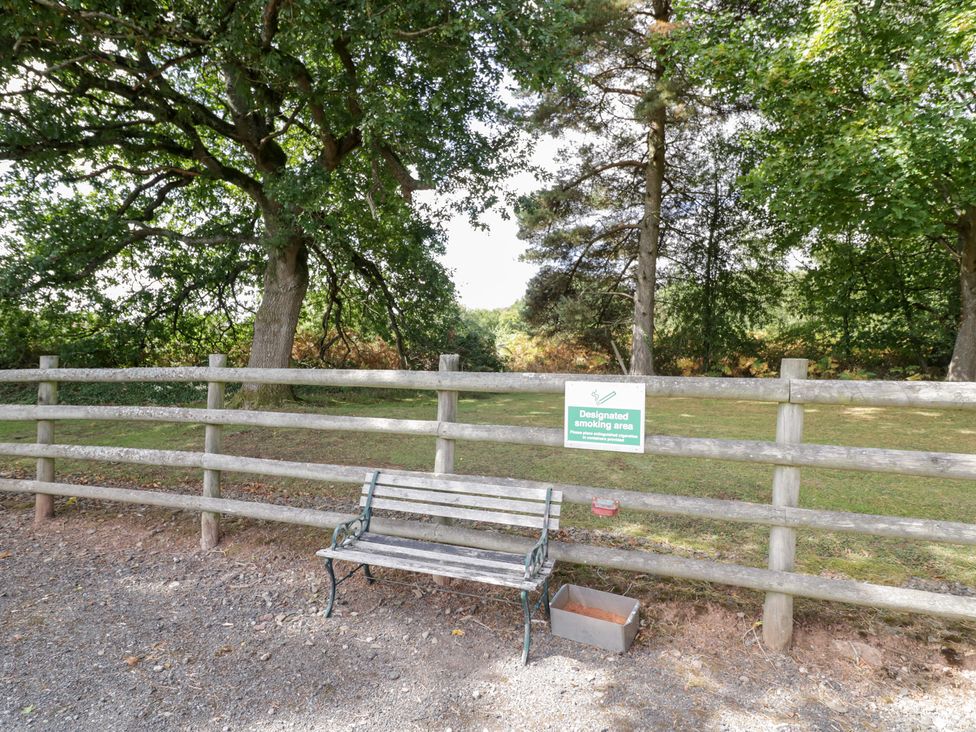An outdoor area with a bench and a designated smoking area sign at Keepers Barn in Bromyard