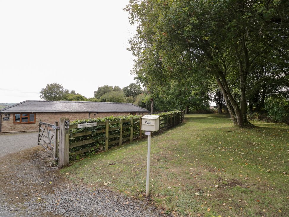 An outdoor area with a building and a post box at Keepers Barn in Bromyard