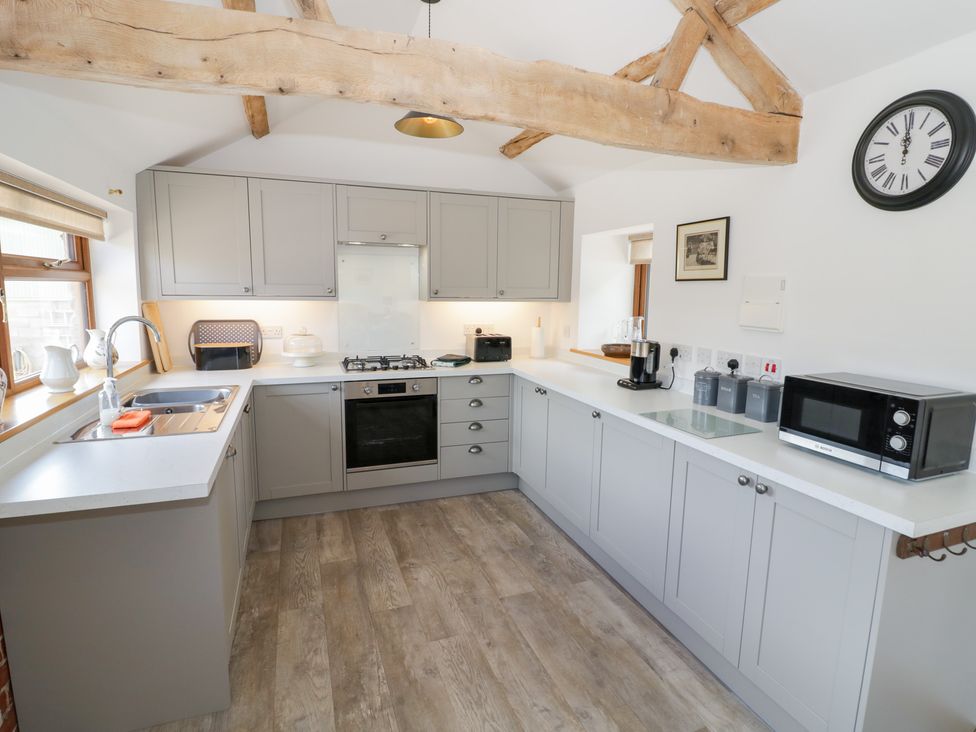A kitchen with gray cabinets and appliances at The Cow Shed in Bromyard