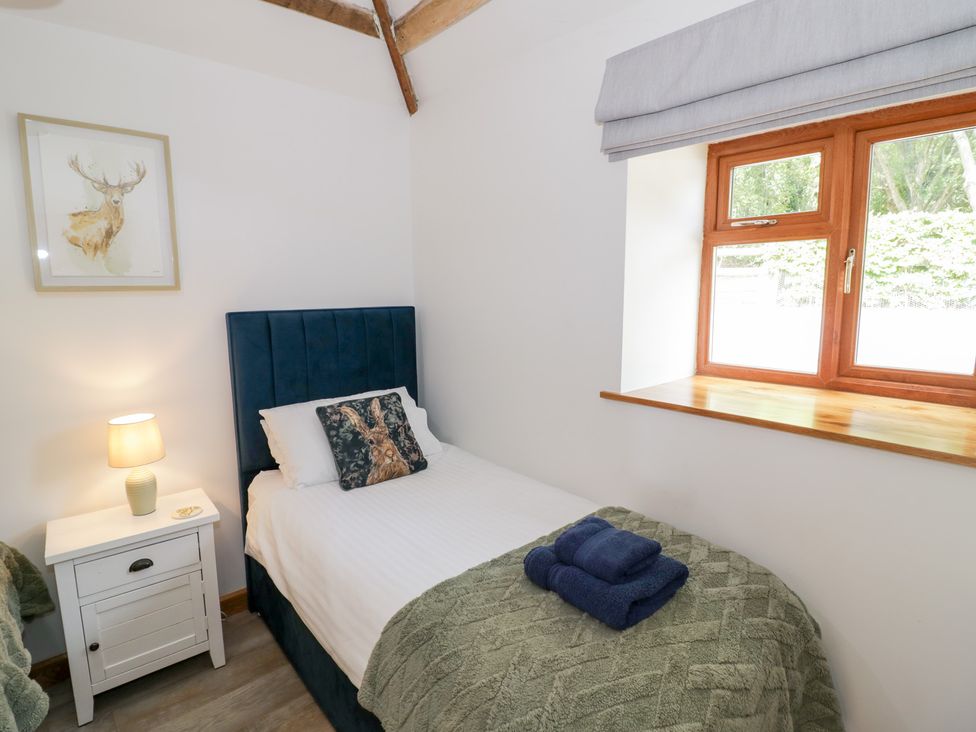 A bedroom with a single bed and window at The Cow Shed in Bromyard