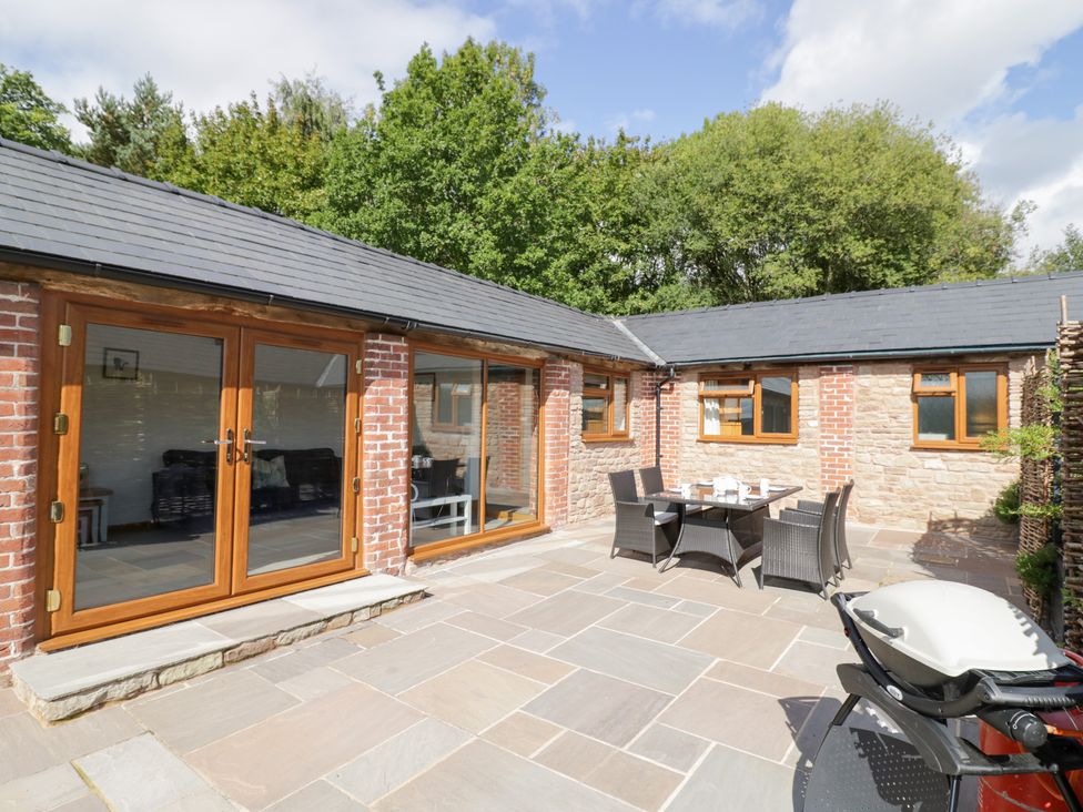An outdoor seating area with a table and chairs at The Cow Shed in Bromyard