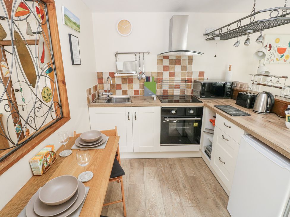 A kitchen with appliances and dining setup at Ty Barddu in Cwmorgan near Newcastle Emlyn