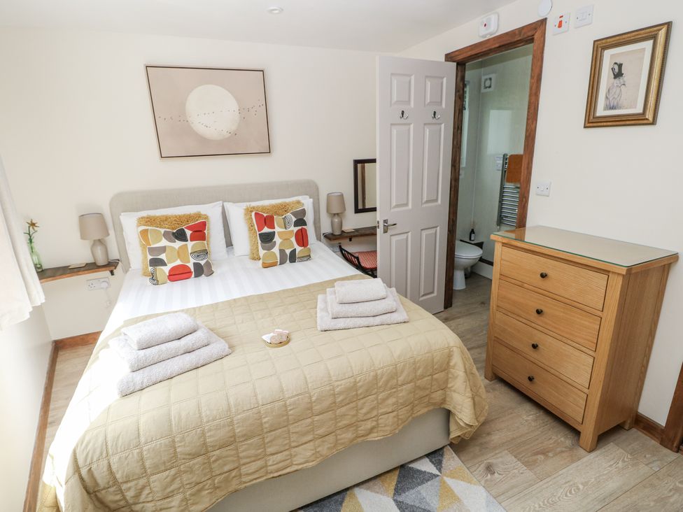 A bedroom with a bed and storage furniture at Ty Barddu in Cwmorgan near Newcastle Emlyn