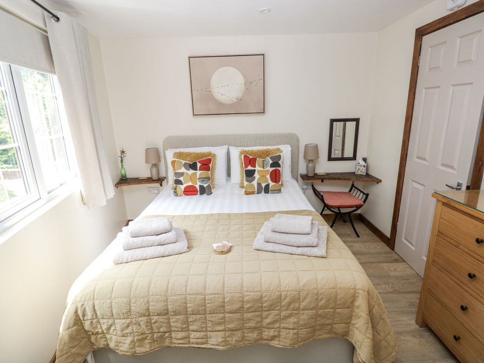 A bedroom with a bed and side table at Ty Barddu in Cwmorgan near Newcastle Emlyn