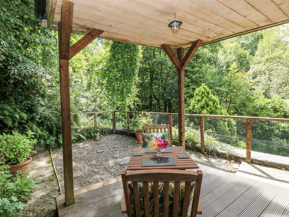 An outdoor patio with a table and chair at Ty Barddu in Cwmorgan near Newcastle Emlyn