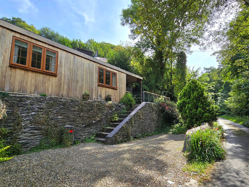 A wooden house with a gravel driveway at Ty Barddu Cwmorgan near Newcastle Emlyn