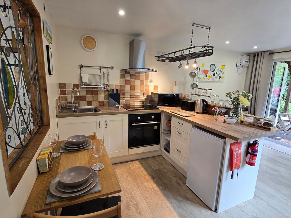 A kitchen with countertops, appliances, and dining area at Ty Barddu, Cwmorgan near Newcastle Emlyn