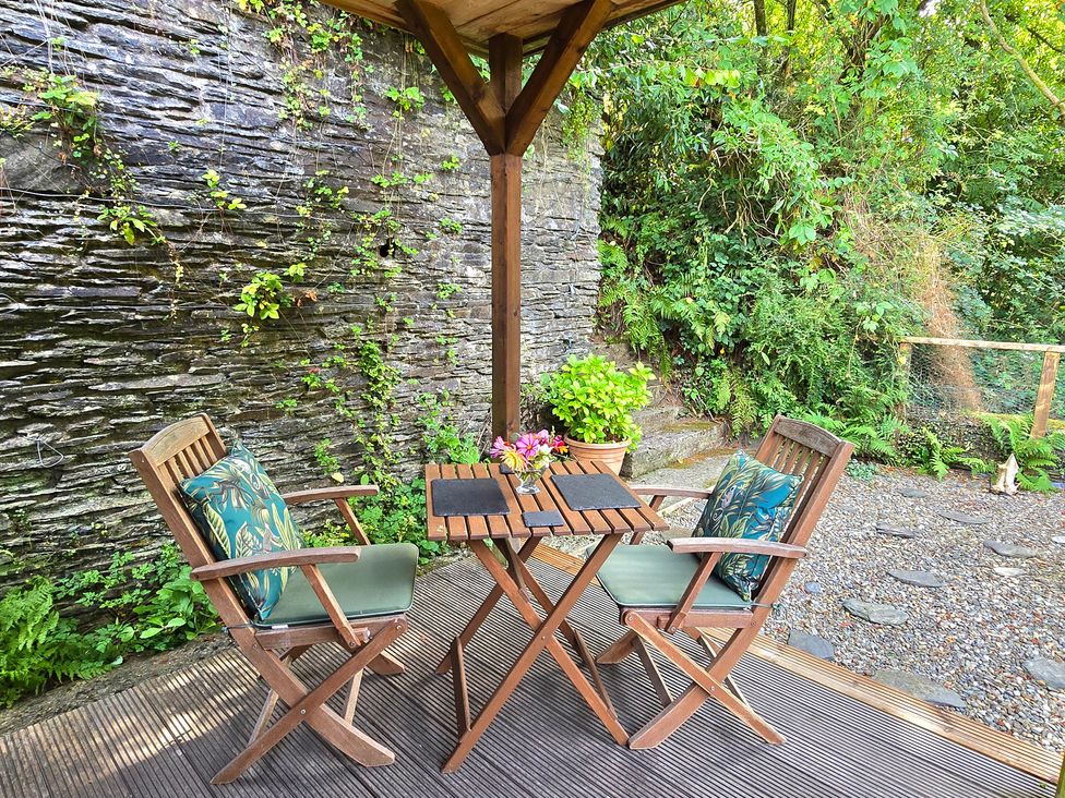 An outdoor area with a table and two chairs at Ty Barddu in Cwmorgan near Newcastle Emlyn