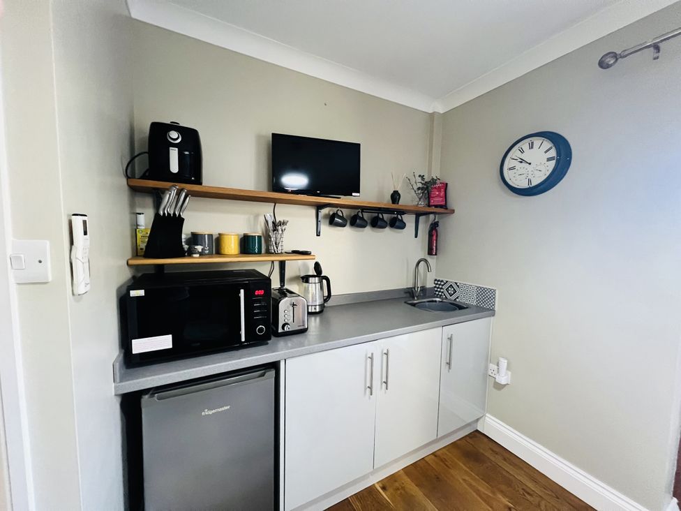A kitchen with appliances including a microwave and fridge at The Annexe Pentlepoir near Kilgetty