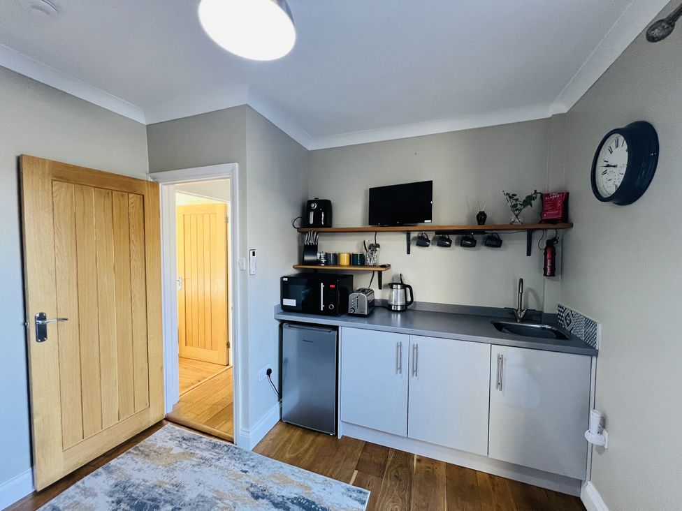 A kitchen with cabinets, a sink, and appliances at The Annexe in Pentlepoir near Kilgetty