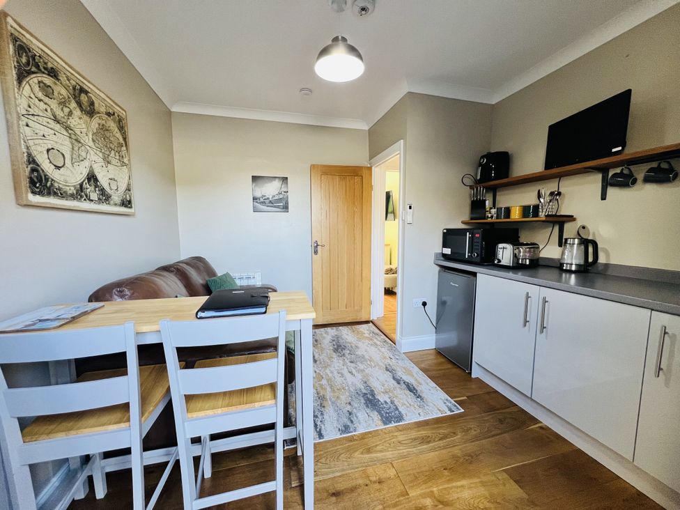 A kitchen with a table and chairs at The Annexe Pentlepoir near Kilgetty