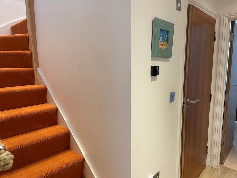 A hallway with stairs and a door at Hamnavoe in Stoke Fleming