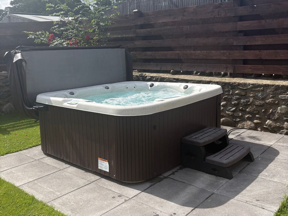 A hot tub with steps in a garden at Yr Hen Stabl, Llanwnda near Bontnewydd, Gwynedd