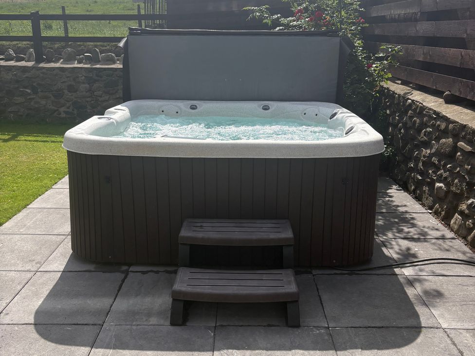 A hot tub with steps on a patio at Yr Hen Stabl Llanwnda near Bontnewydd Gwynedd