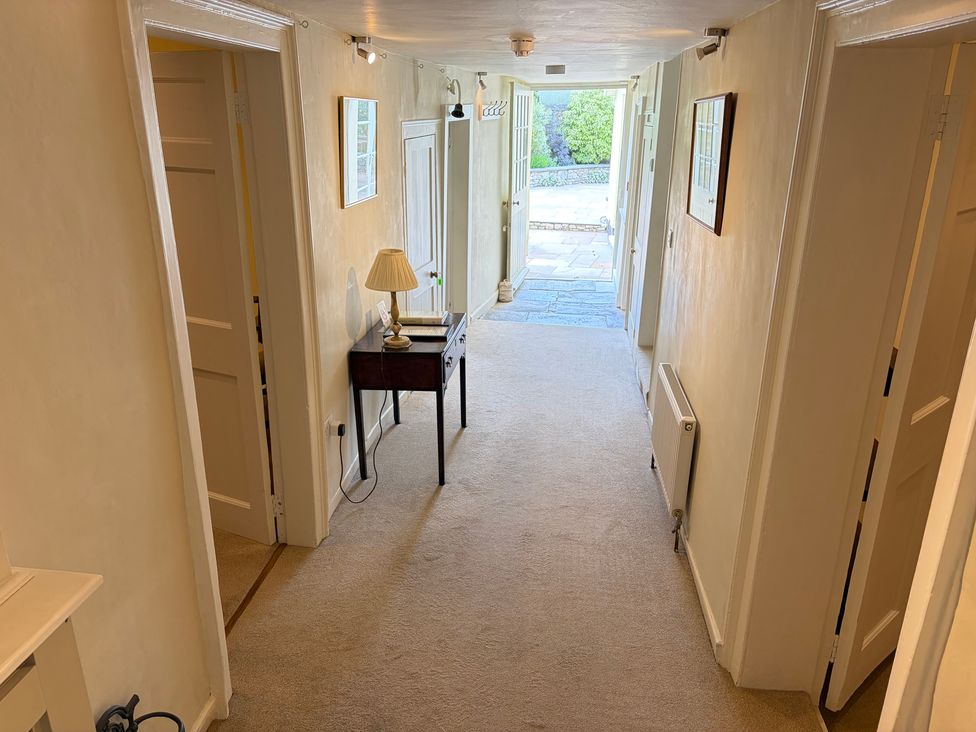 A hallway with a table and lamp at Malabar House in Lyme Regis