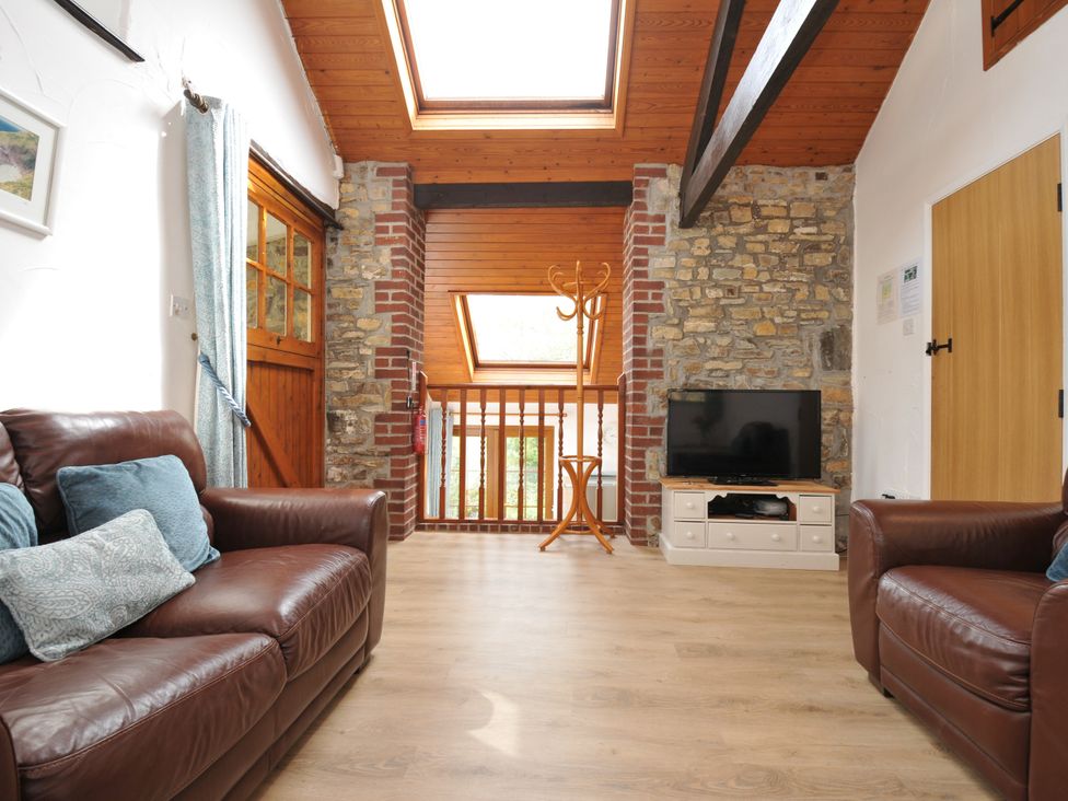 A living room with a sofa and television at Shipload Cottage in Hartland