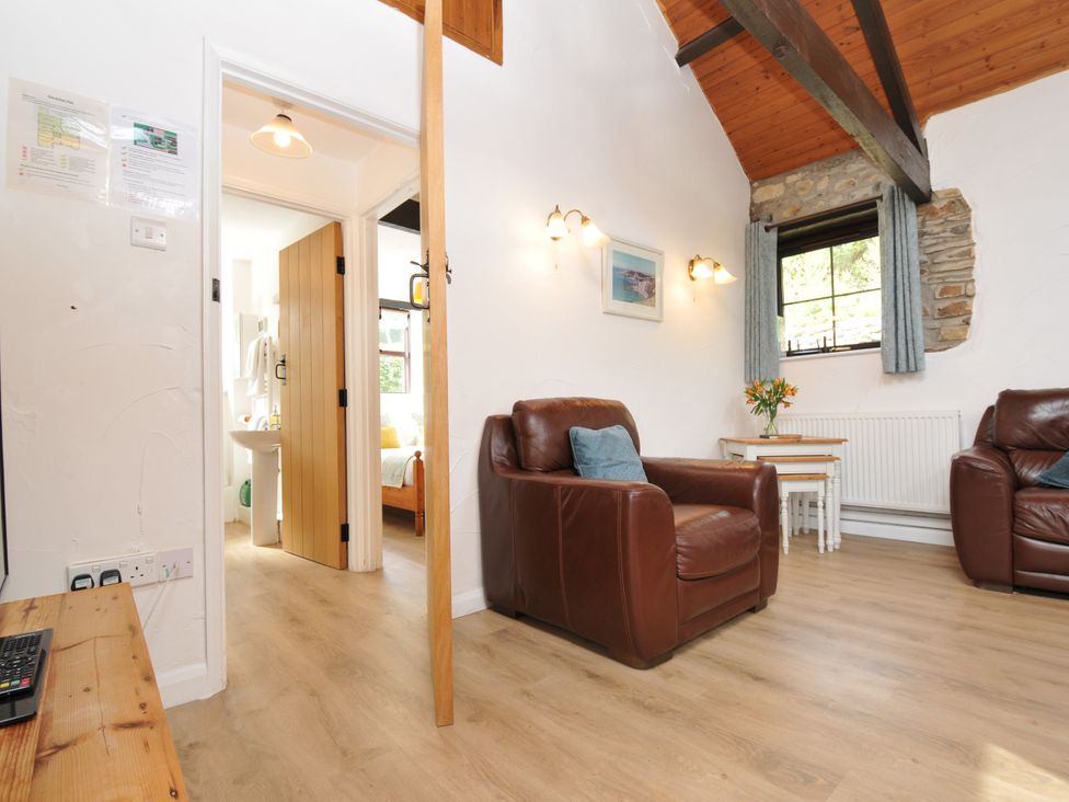A living room with chairs and a table at Shipload Cottage in Hartland