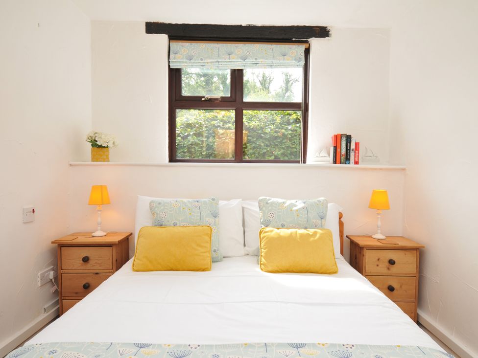 A bedroom with a bed and nightstand at Shipload Cottage in Hartland