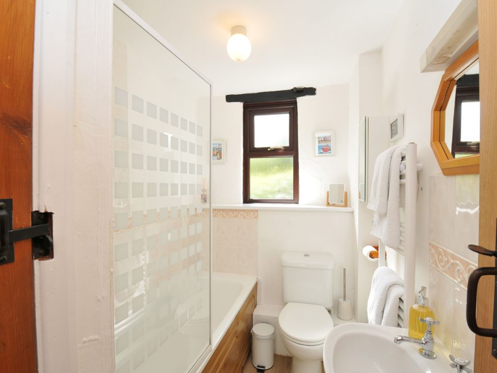A bathroom with a shower and bathtub at Shipload Cottage Hartland