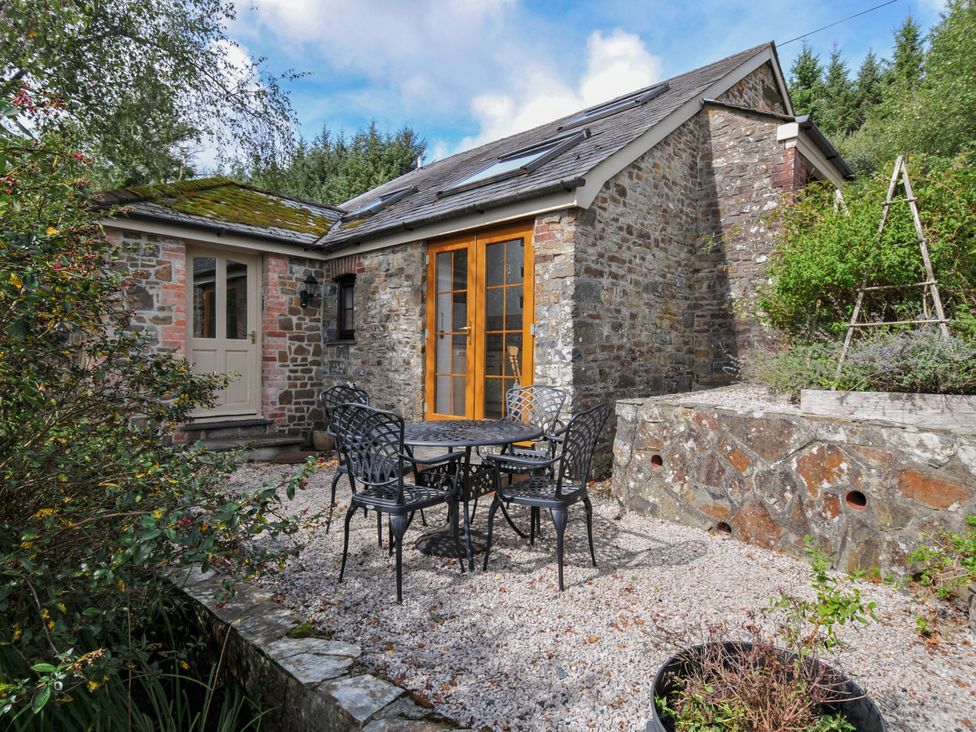 A table with chairs in an outdoor area at Shipload Cottage in Hartland