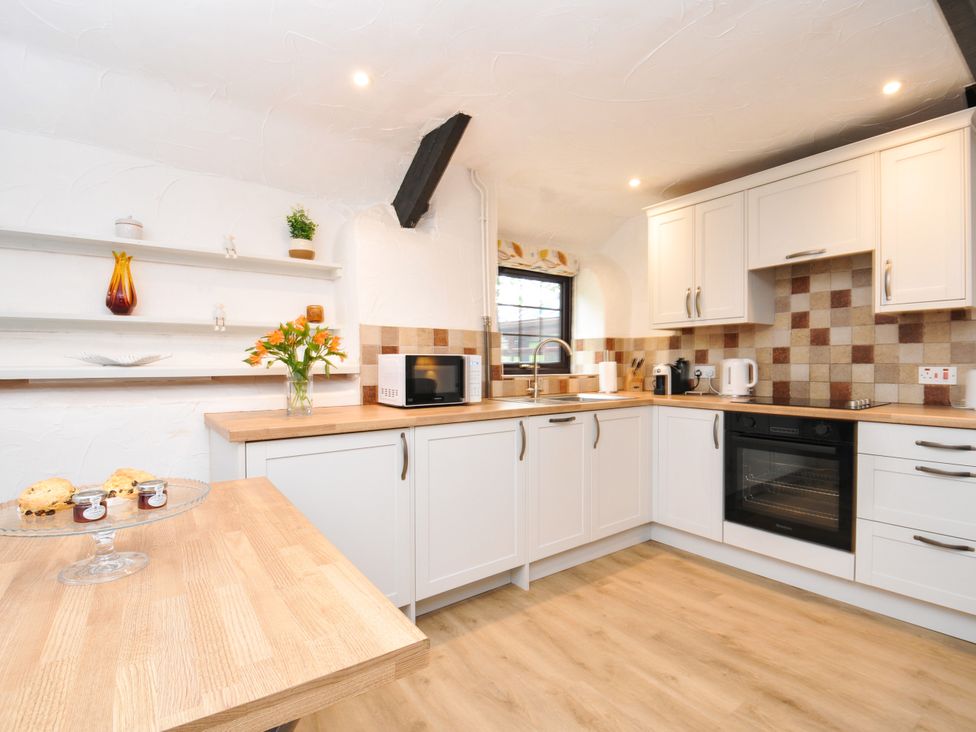A kitchen with appliances and shelves at Windbury Cottage in Hartland