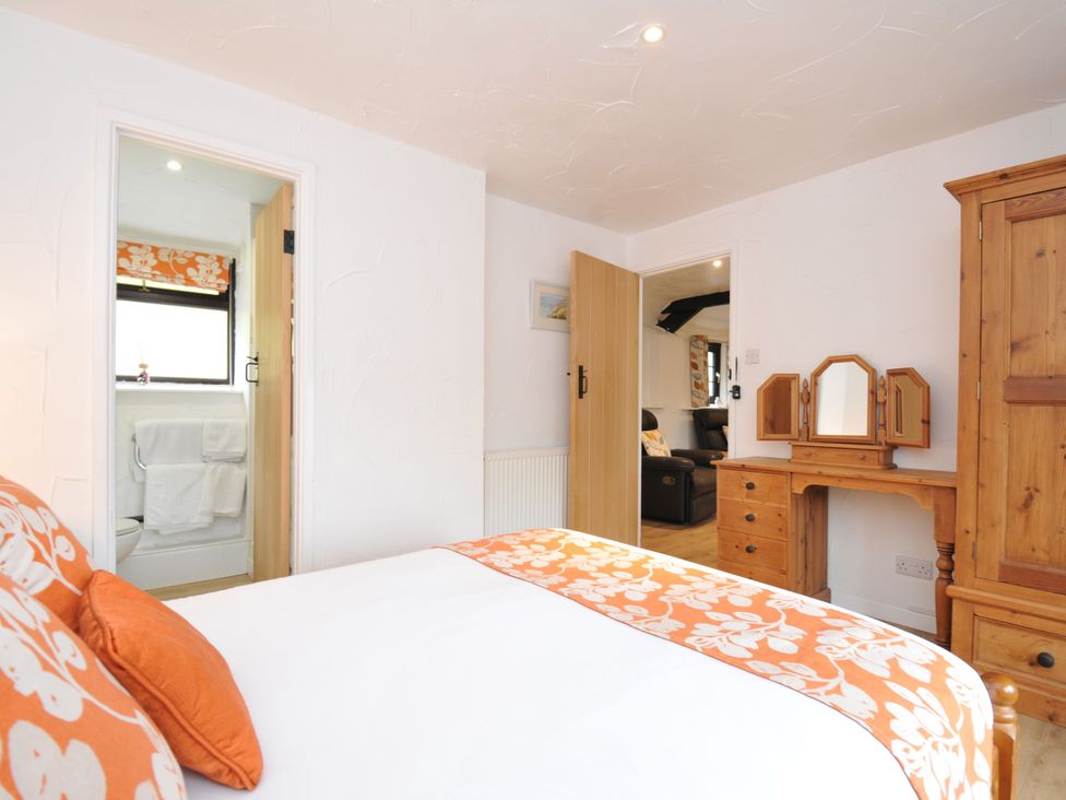 A bedroom with a bed and a dresser at Windbury Cottage in Hartland
